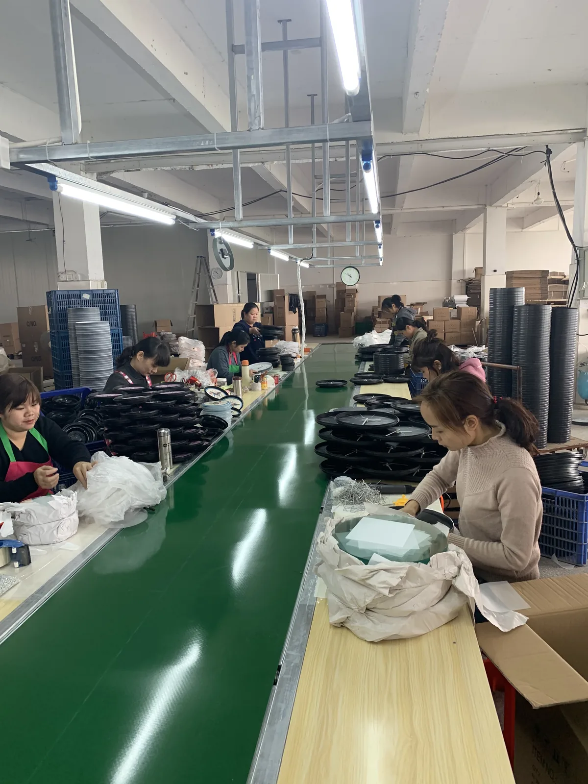Bonmo Clock production floor with workers assembling custom wall clocks