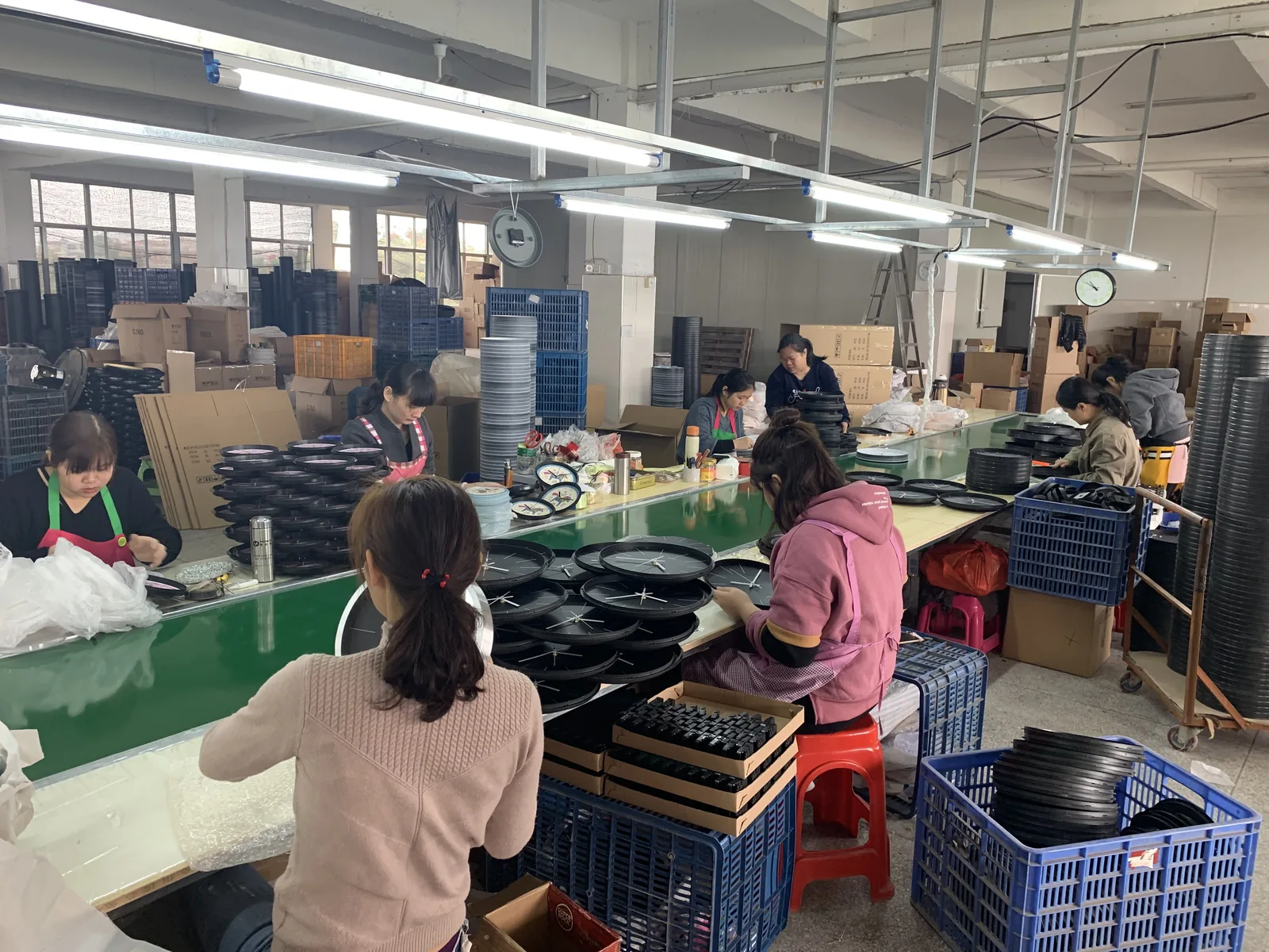Bonmo Clock production floor with workers assembling custom wall clocks